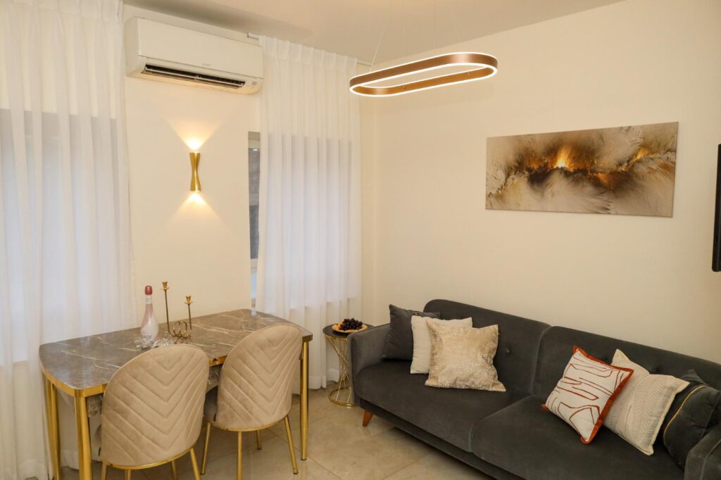 Cozy modern living room with elegant decor, marble dining table, stylish wall art, and ambient lighting.