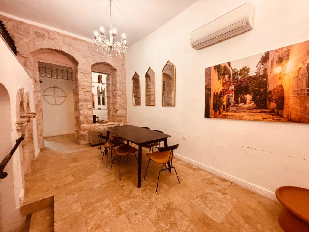 Bright dining room with exposed stone walls, modern art, and warm ambient lighting.