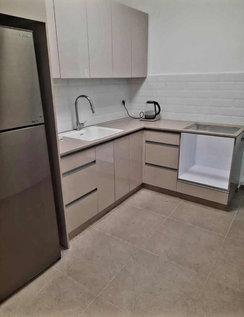 Stainless steel refrigerator, white cabinetry, countertop with electric kettle, modern kitchen setup.