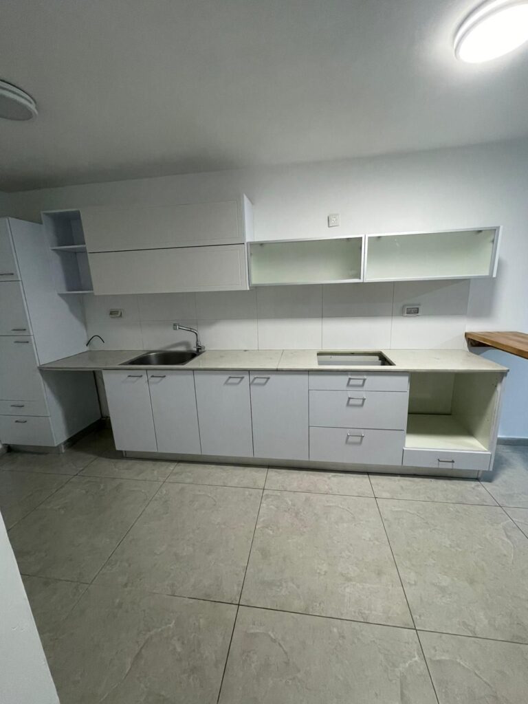 White minimalist kitchen with built-in cabinets and open shelving for modern home decor.