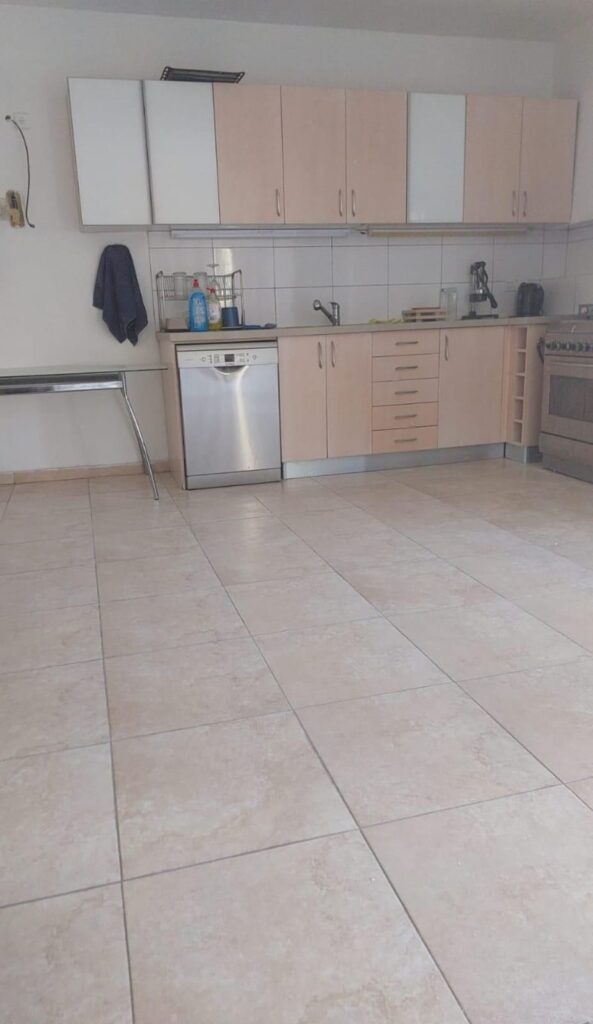 Clean modern kitchen with beige cabinets and stainless steel appliances.