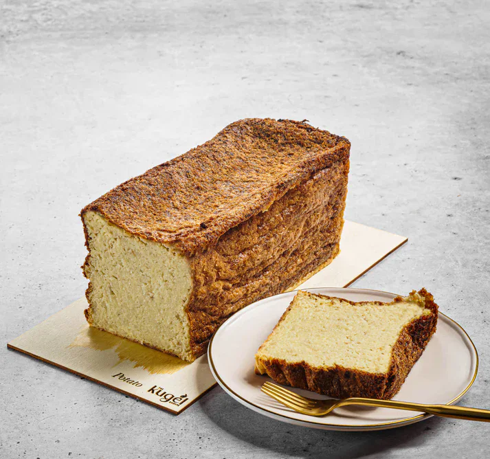Fluffy homemade yeast bread with golden crust on white background.
