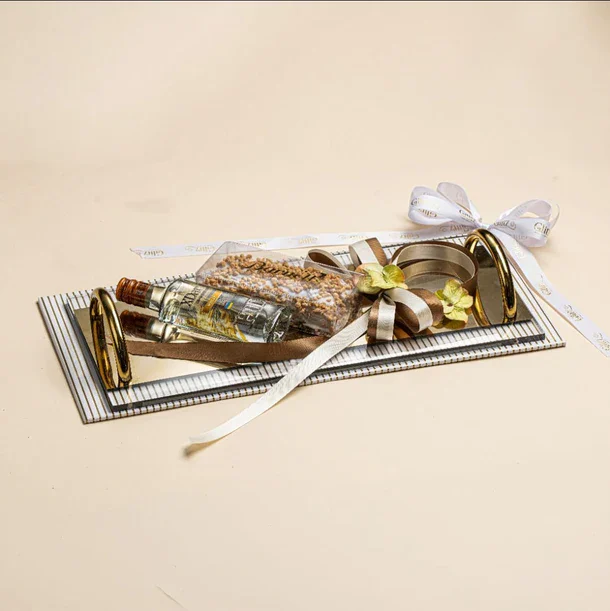 Beautiful gift arrangement featuring ribbons, a small bottle, and decorative elements.