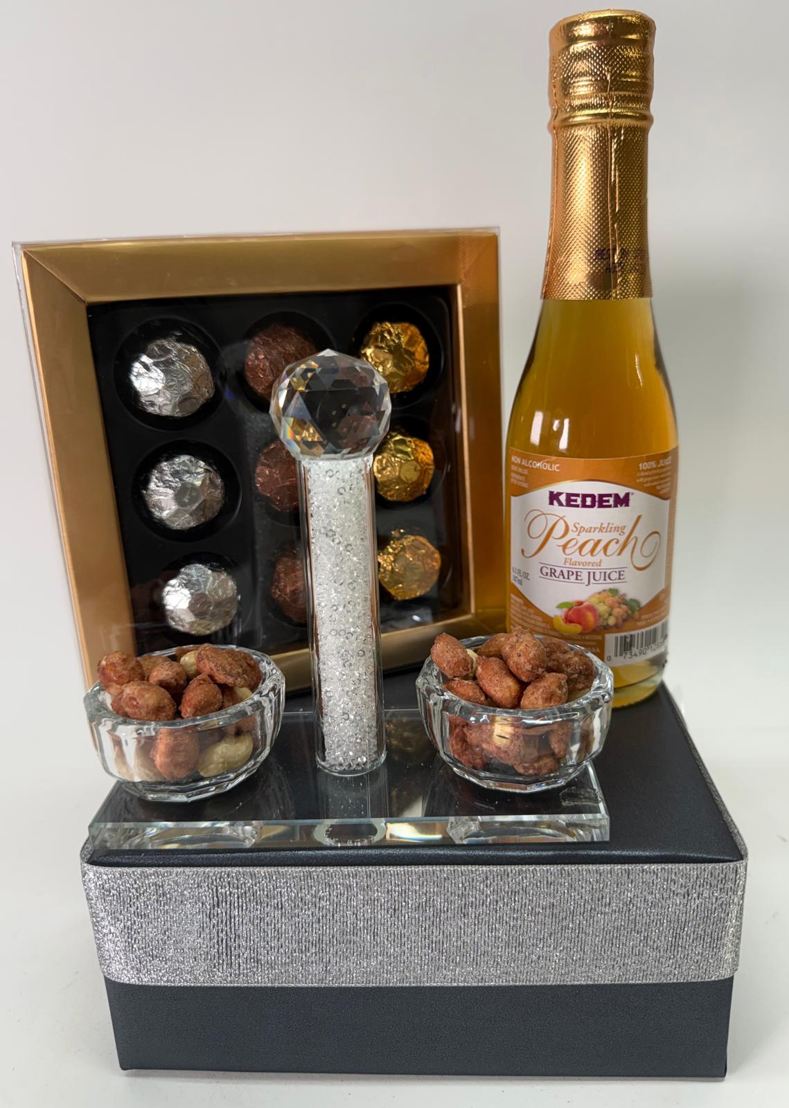 Luxurious gift set with champagne, chocolates, and snacks on a decorative tray.