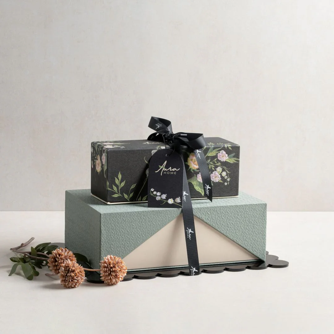 Beautiful gift boxes wrapped with floral paper and a black ribbon bow, ideal for celebrations.