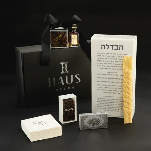Elegant gift set with pasta, a book, and decorative items on a black background.