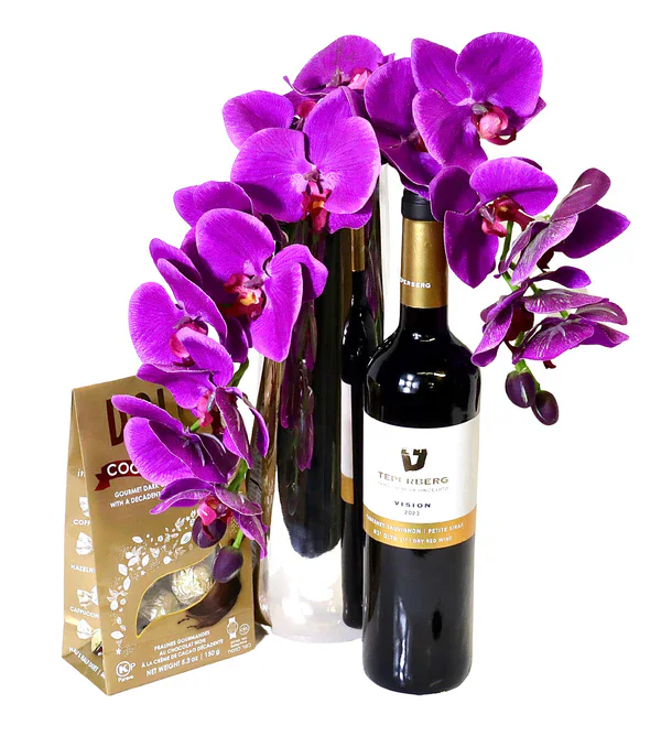 Elegant purple orchids with two wine bottles and a gift box for special occasions.