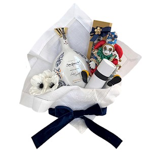 Gift basket with wine, holiday ornaments, and decorative items for celebrations.