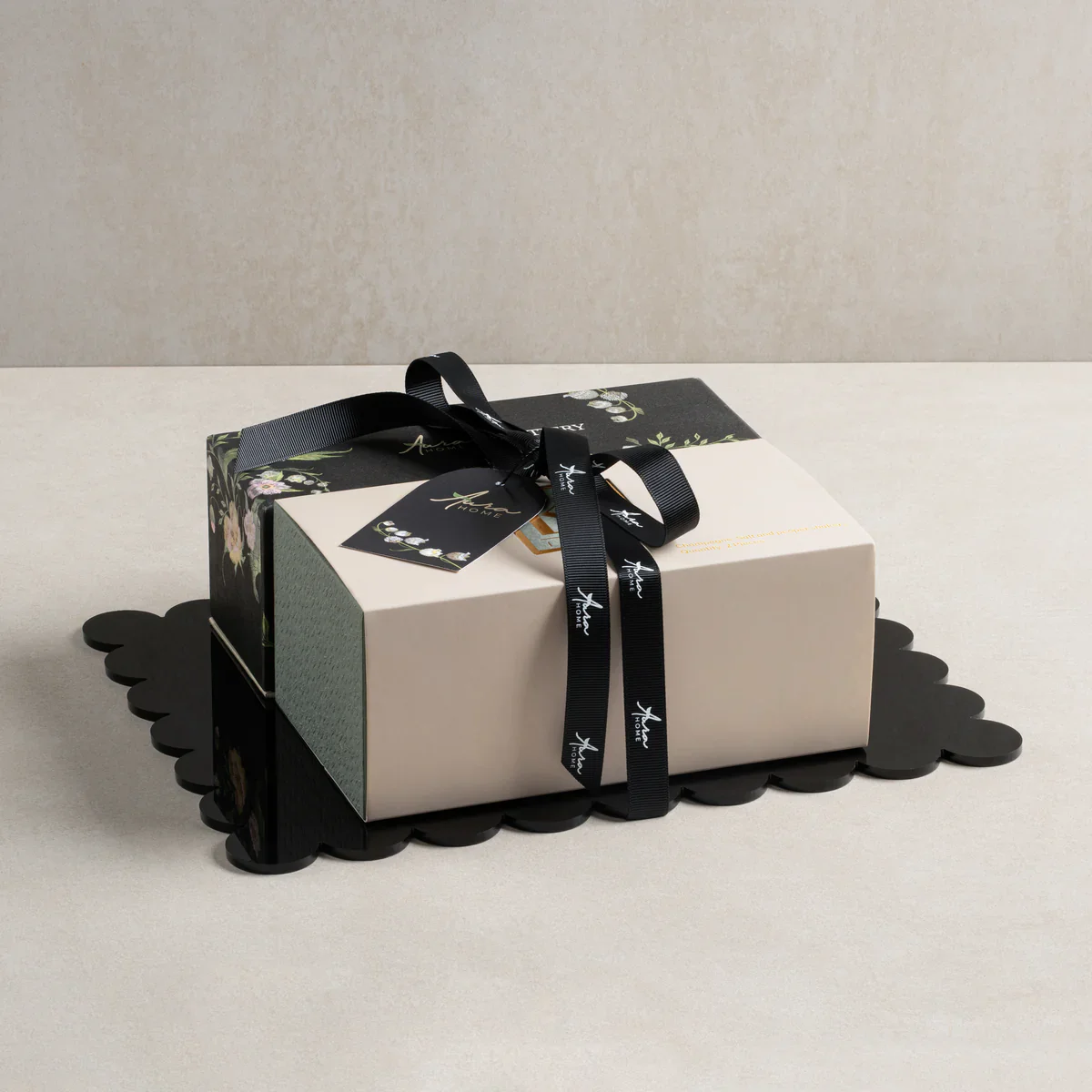 Elegant gift box with black ribbon and floral wrapping, perfect for special occasions.